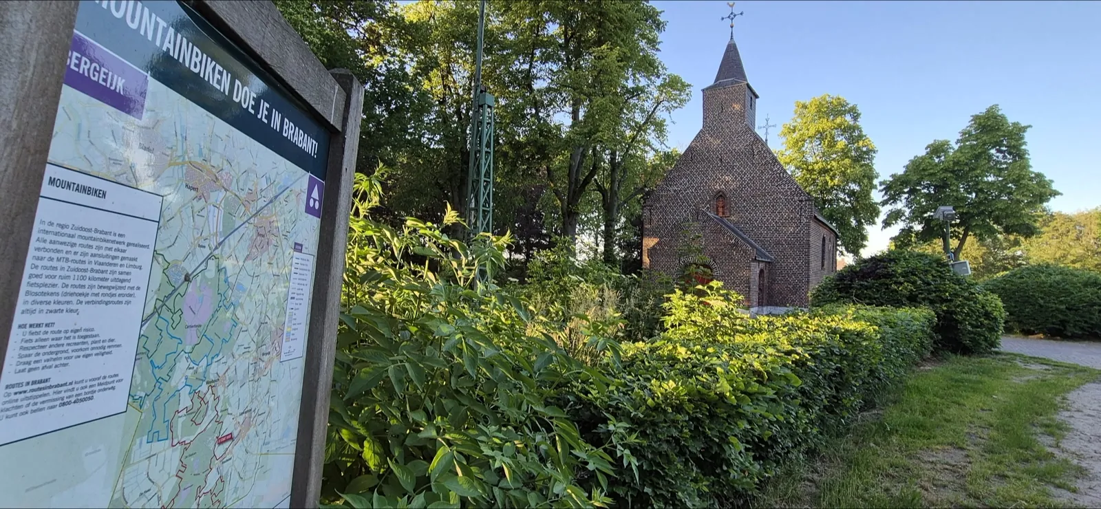 Startbord van het Brabantse mountainbikenetwerk bij een Kempens kerkje